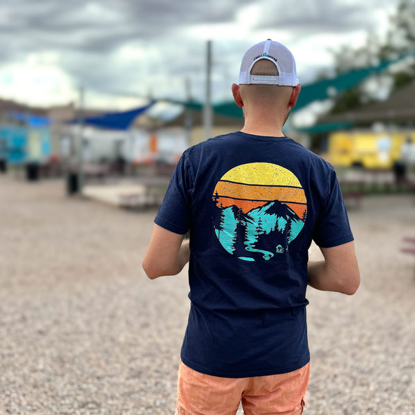 Rear view of a man at a food truck park wearing the Mountain Sunrise Graphic Tee