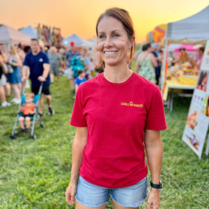 Front view of a woman wearing the Chill Your Monkee Sunset Graphic Tee at a hot air balloon festival