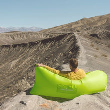 Load image into Gallery viewer, Man resting in a green Chill Monkee inflatable lounger at the end of a hike
