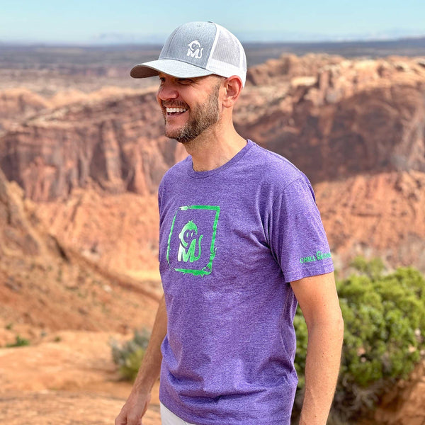 Side view of a man wearing the Iconic Monkee Graphic Tee while hiking