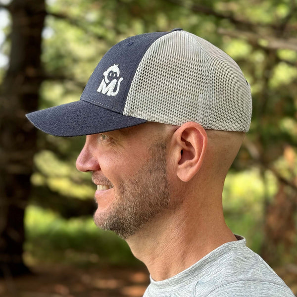 Side view of a man wearing the Iconic Monkee Low Pro Trucker Hat in navy heather and light grey