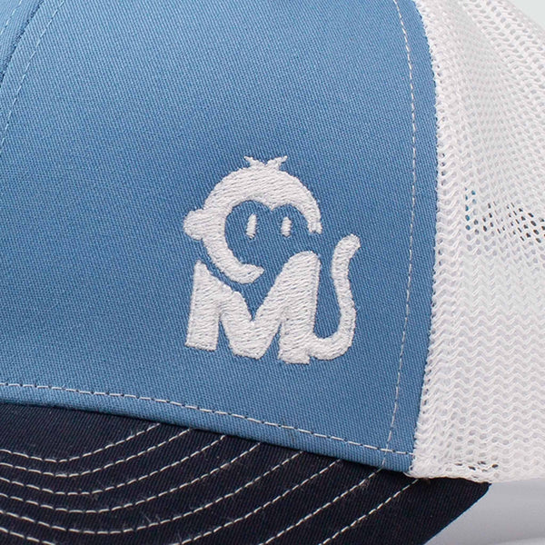 Close-up view of the Iconic Monkee Mid Pro Trucker Hat in Columbia blue, white, and navy