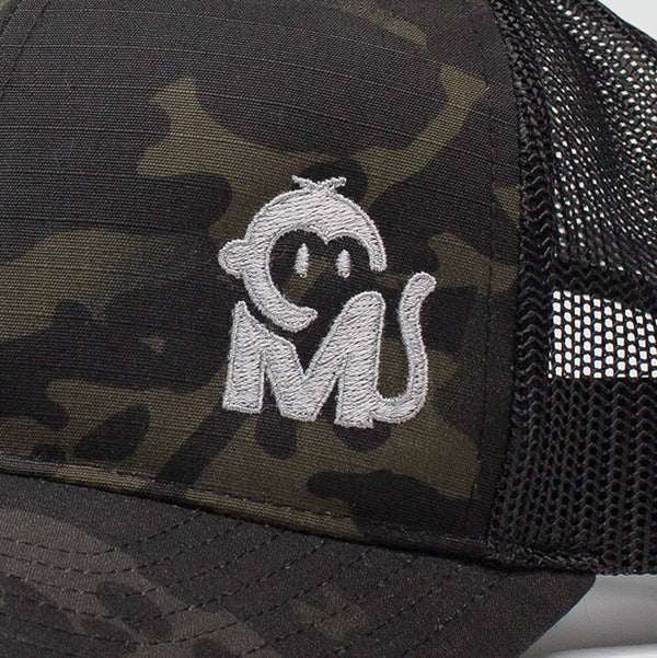 Close-up view of the Iconic Monkee Multicam Trucker Hat in black and black