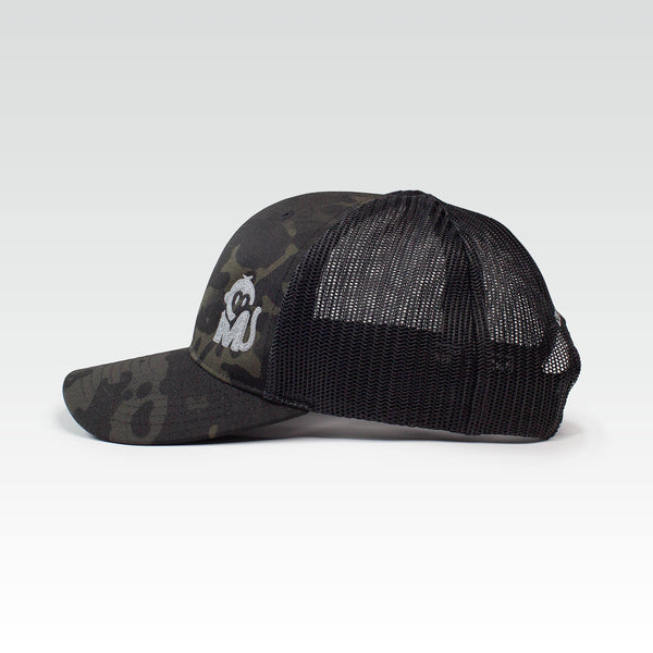 Side view of the Iconic Monkee Multicam Trucker Hat in black and black