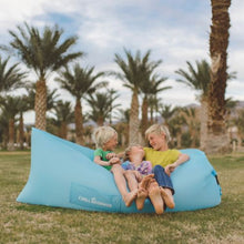 Load image into Gallery viewer, Three young boys sitting in a light blue Chill Monkee inflatable lounger at a park
