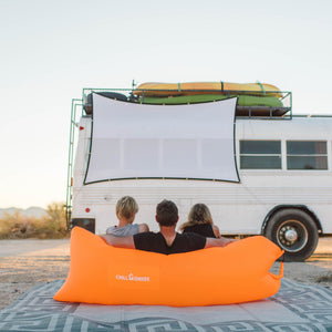 Family using a Chill Monkee Orange Lazy Lounger for an outdoor movie night.