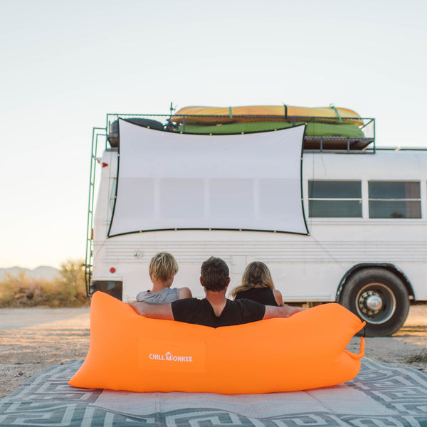 Family using a Chill Monkee Orange Lazy Lounger for an outdoor movie night.
